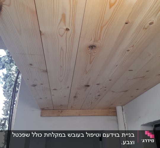 תקרת עץ עם קרש תומך על קיר גבס